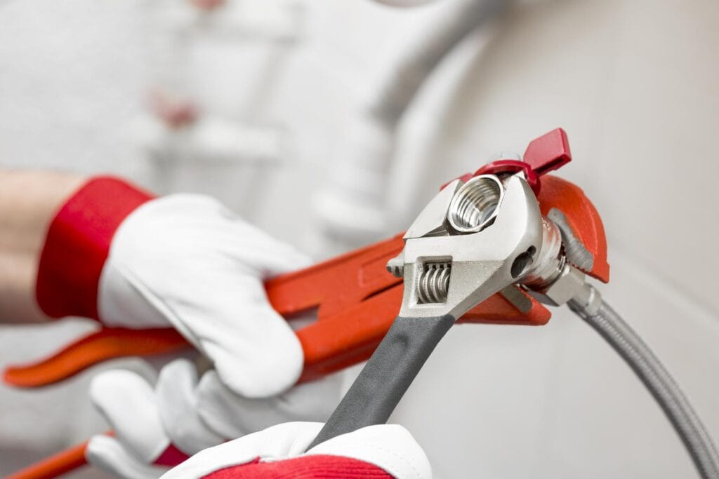 Plumber holding pipe wrenches for an emergency repair in Lake Elsinore
